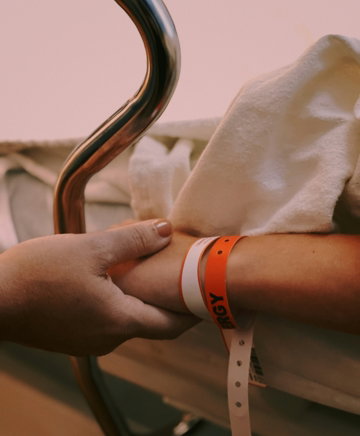 person wearing orange and white silicone band