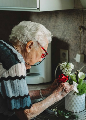 woman fixing flowers in pot