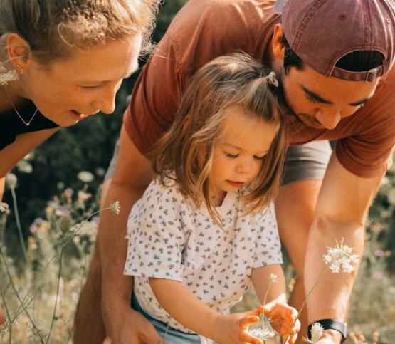 A man and two little girls in a field